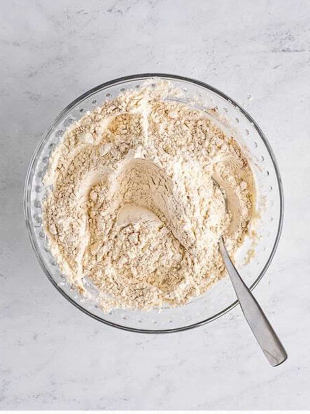 Dry ingredients whisked together in a glass bowl for Pumpkin Cake.