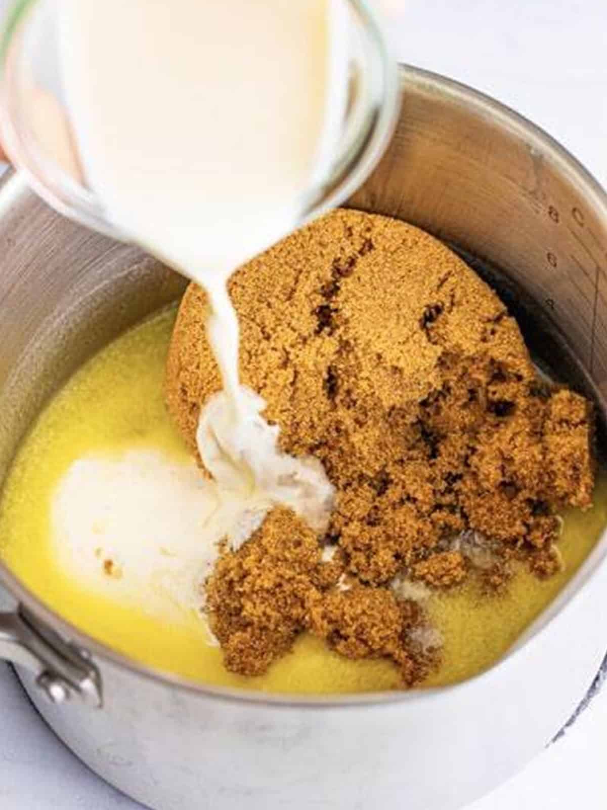 Butter, dark brown sugar, and heavy cream in a saucepan for praline frosting.