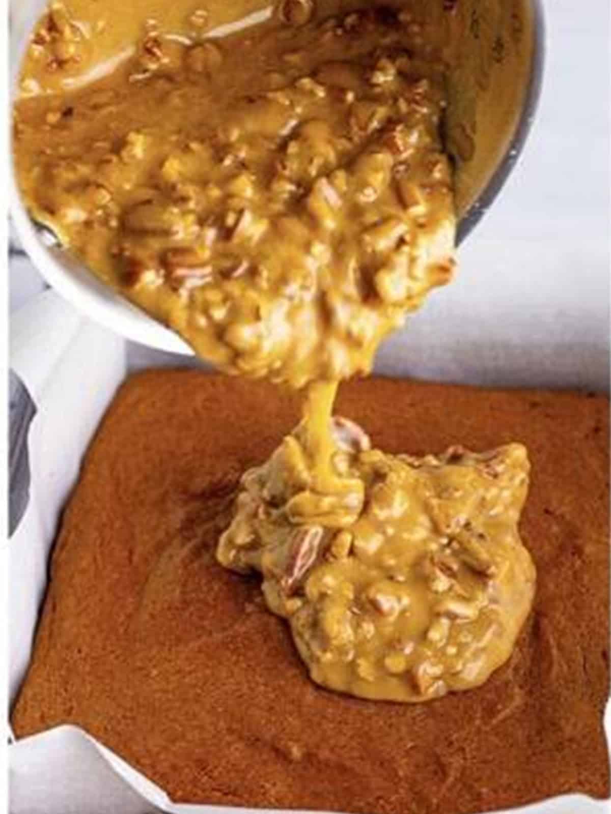 Warm praline frosting poured over the baked pumpkin cake in the pan.