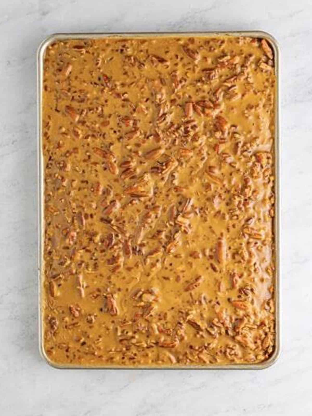 Bourbon praline pecan frosting poured over the Pumpkin Cake.