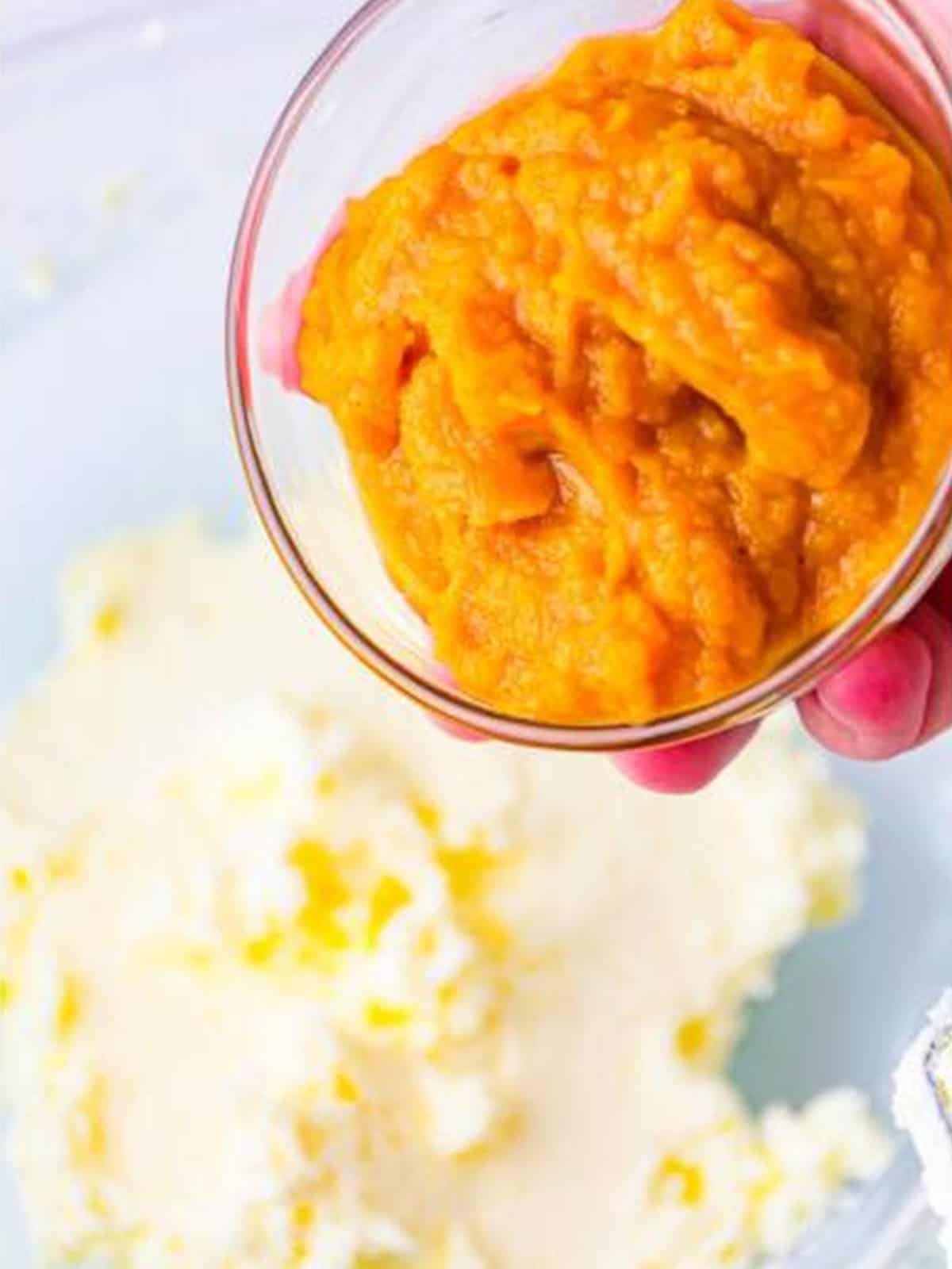 Pumpkin puree being added to the whipped cream cheese mixture.