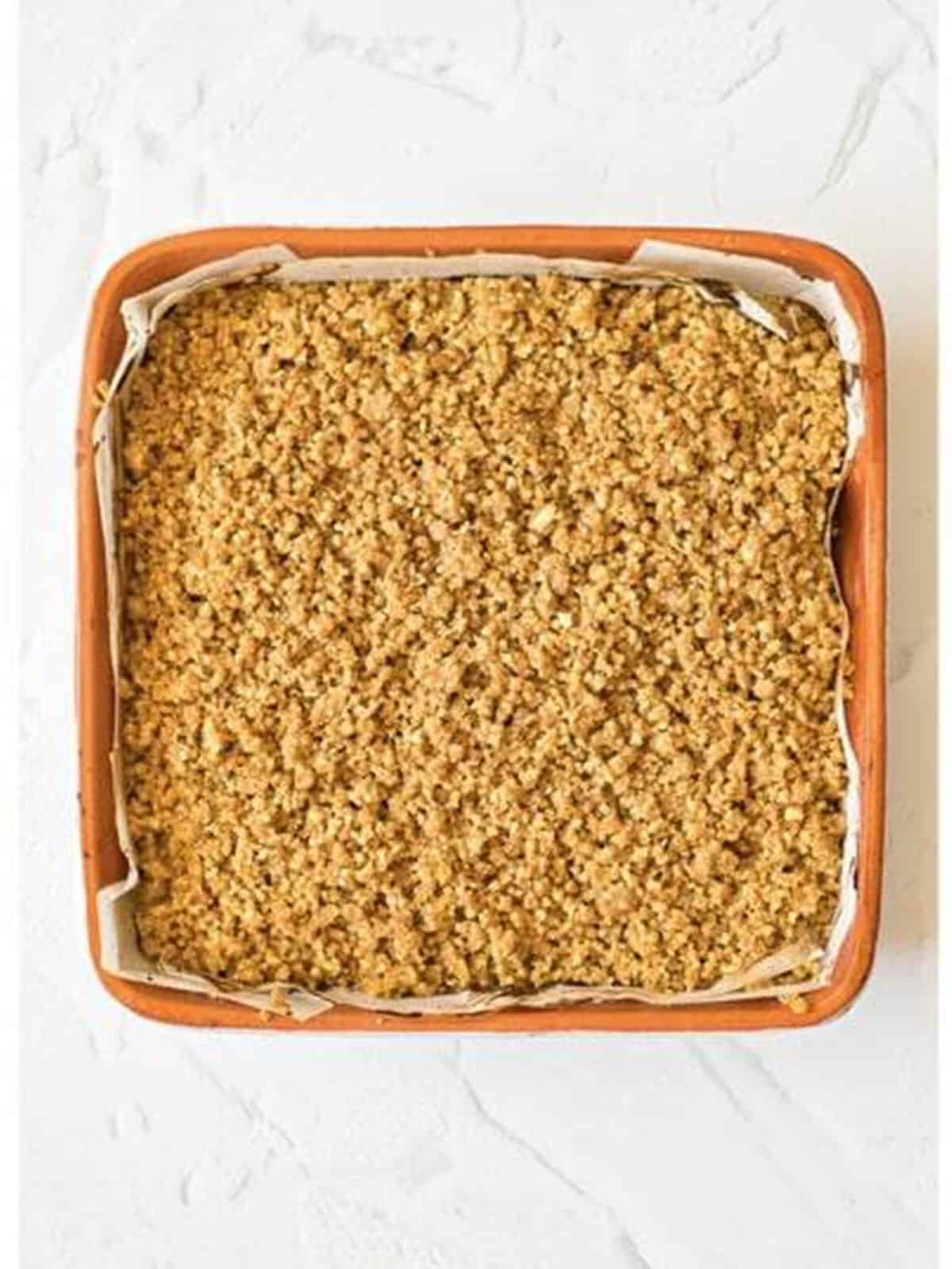 Walnut crumble scattered over the pumpkin cheesecake bars before the final bake.