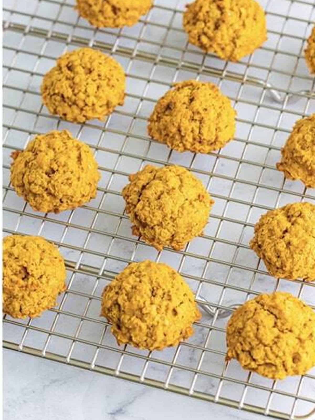 Baked pumpkin cookies cooling on a wire rack.