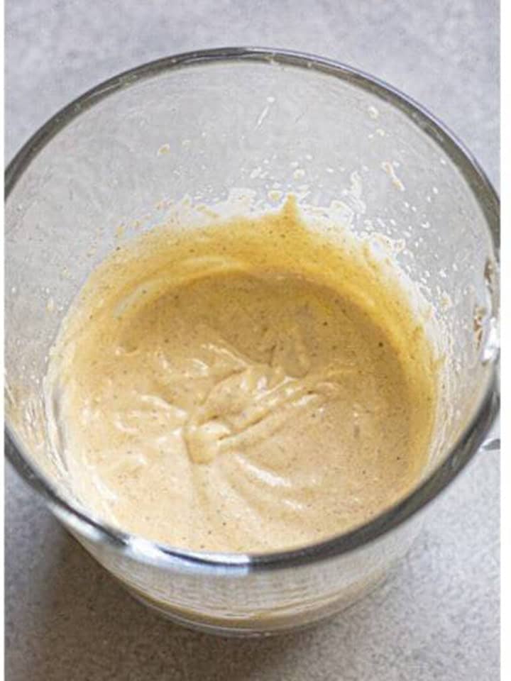 Pumpkin sweet cream whipped to soft peaks in a glass measuring cup.