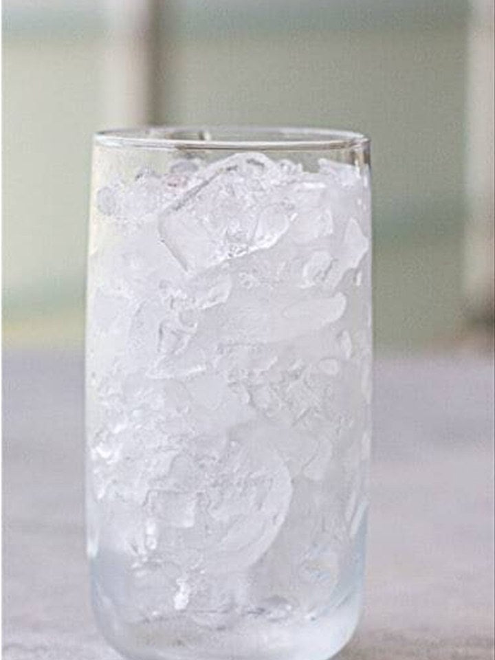 A tall serving glass filled to the top with ice.