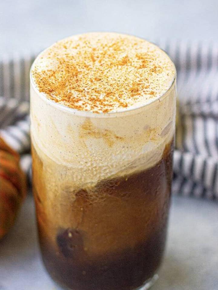 Fluffy pumpkin cream floating on top of cold brew with a cinnamon garnish.