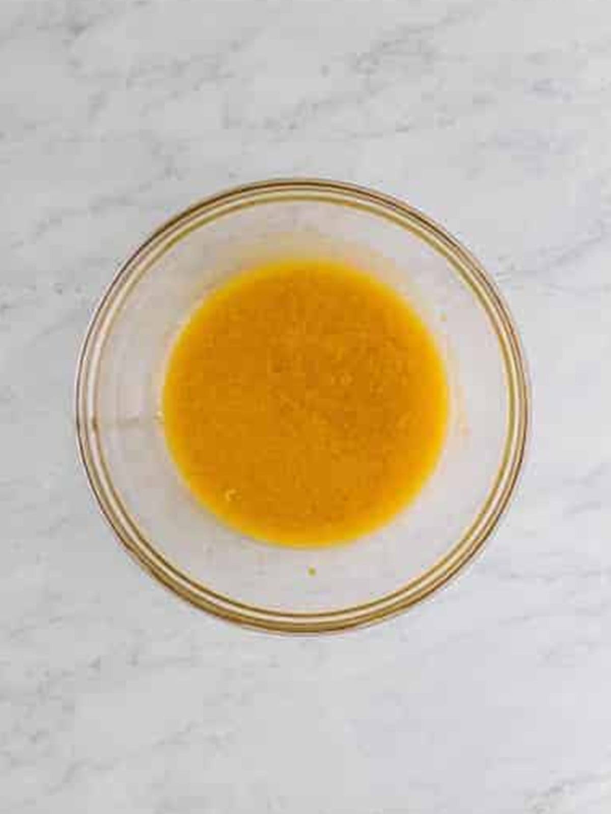 Whisking the eggs, brown sugar, granulated sugar, and oil together until smooth in a glass bowl.