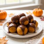 A plate of chocolate glazed Pumpkin Donut Holes.