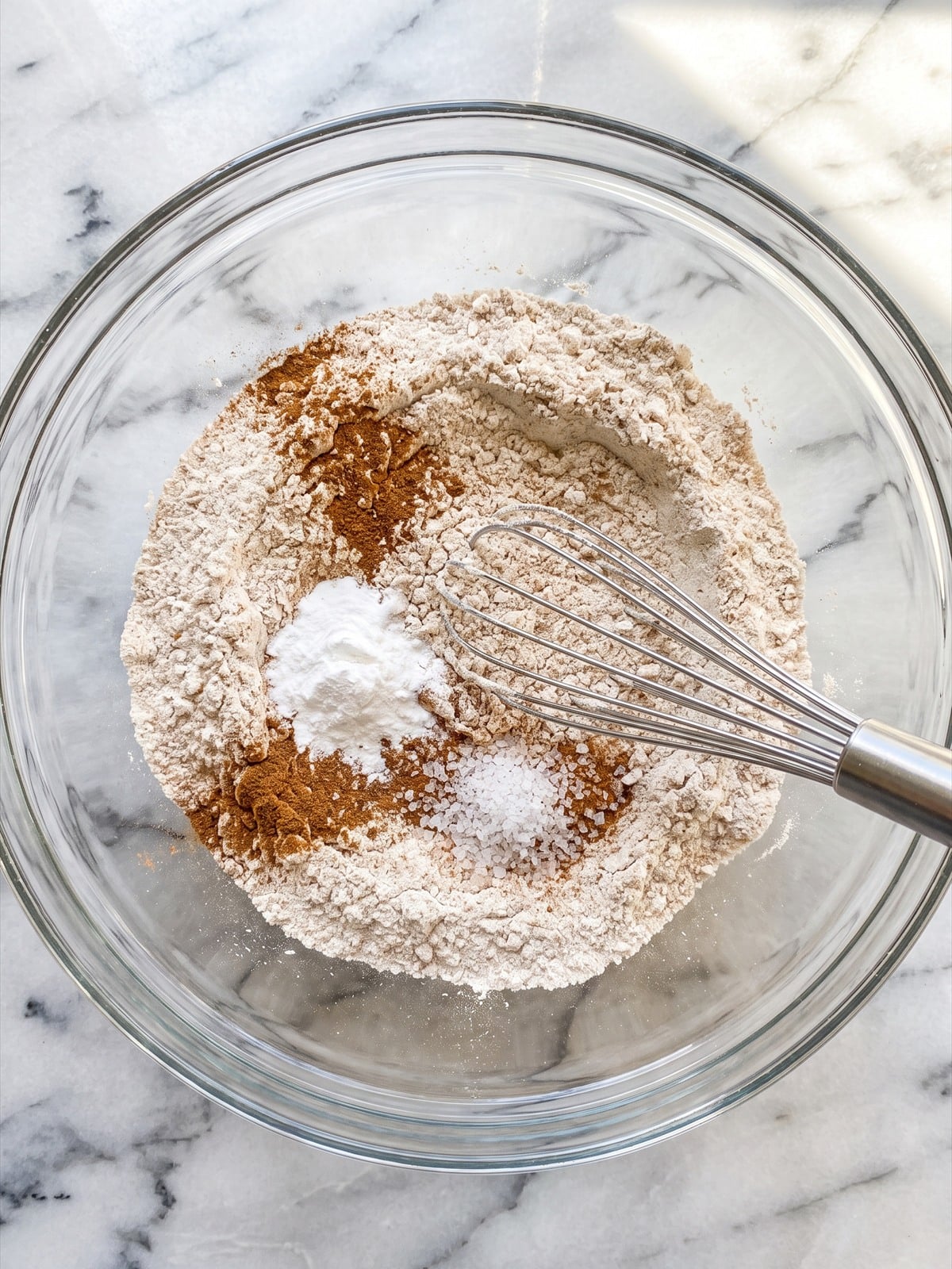 Flour, pumpkin pie spice, baking powder, and salt whisked together in a bowl.