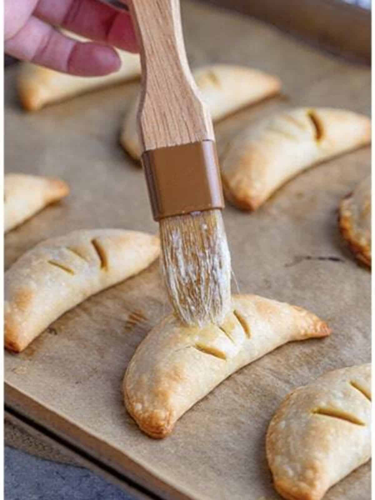 Baked Pumpkin Hand Pies brushed with melted butter.