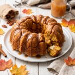 A pull-apart Pumpkin Monkey Bread on a plate with gooey cinnamon glaze.