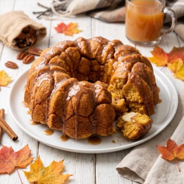 A pull-apart Pumpkin Monkey Bread on a plate with gooey cinnamon glaze.