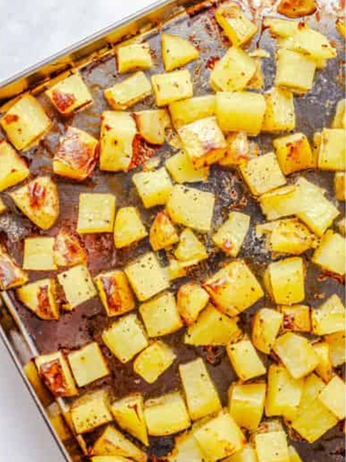 Golden roasted potato cubes on the sheet tray for Ranch Potato Salad.