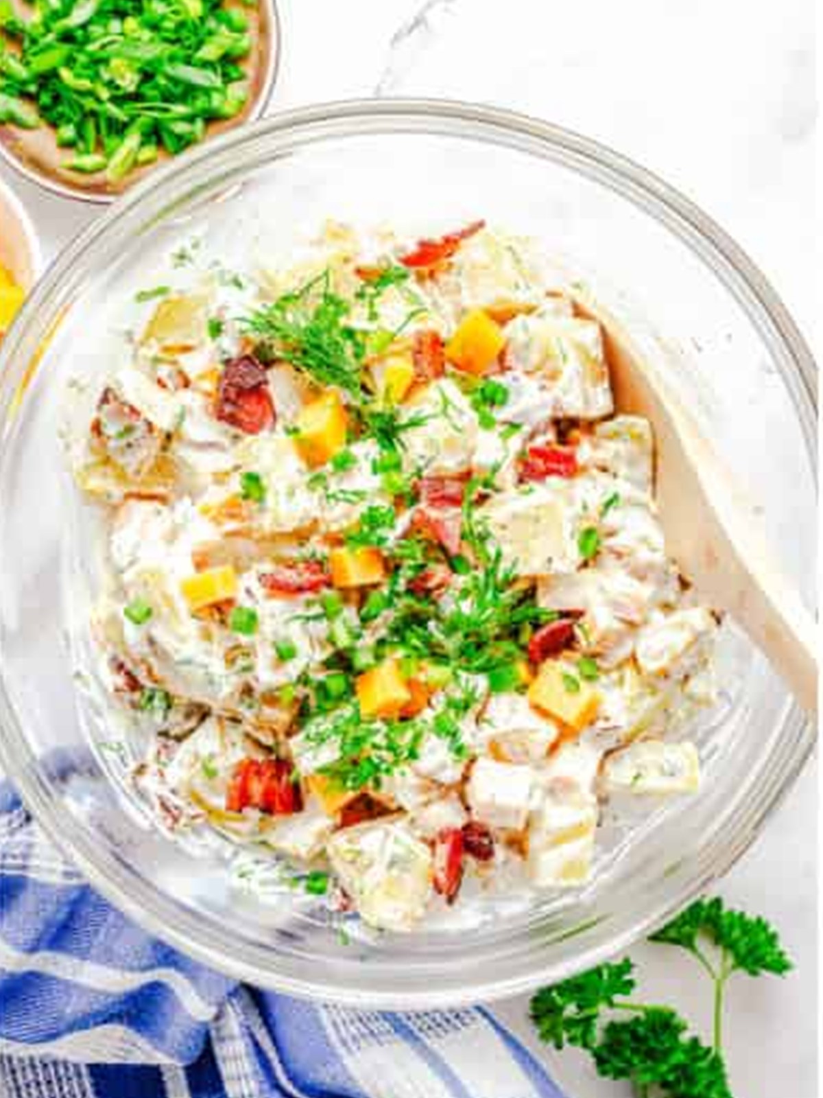 Finished Ranch Potato Salad in a glass serving bowl garnished with fresh dill.