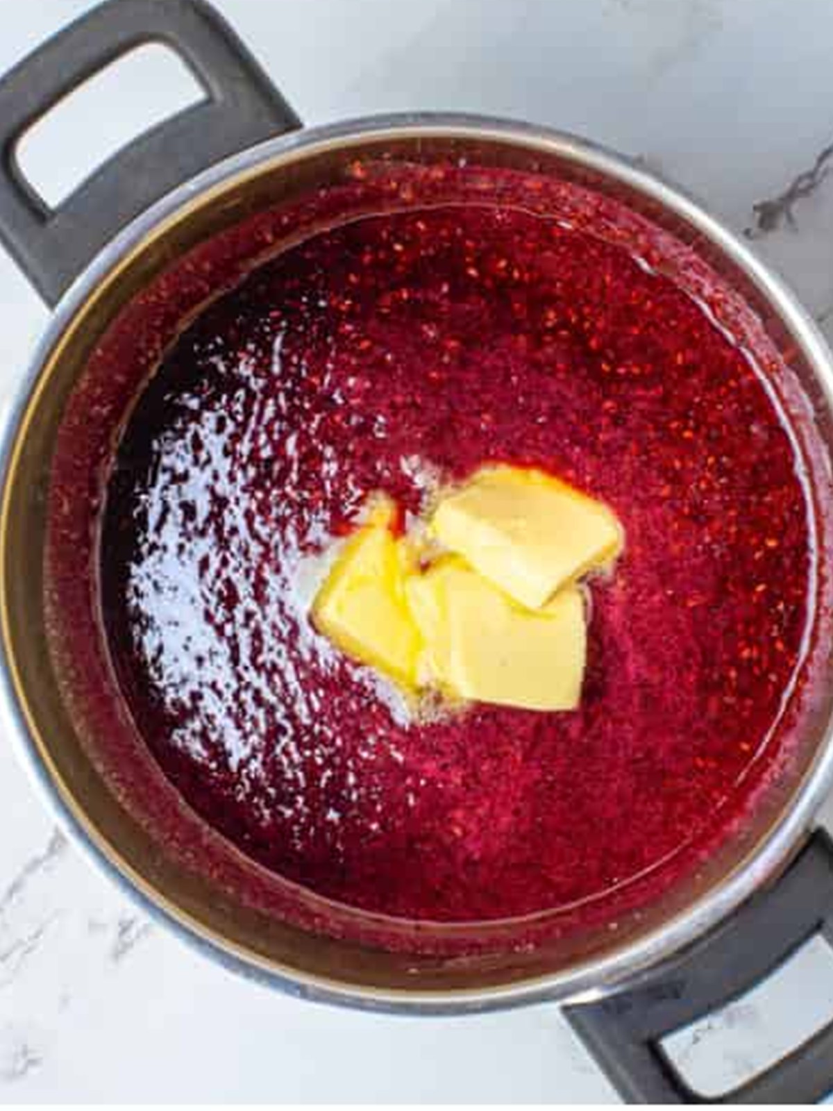 Butter, vanilla, and salt stirred into the hot Raspberry Curd off the heat.