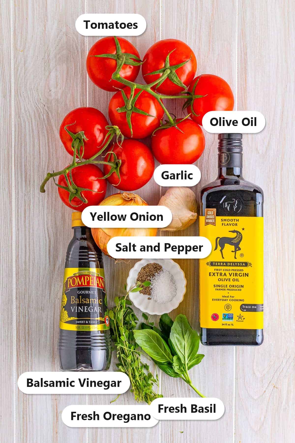 Labeled ingredients for Roasted Tomato Sauce: fresh tomatoes, yellow onion, garlic, olive oil, balsamic vinegar, fresh oregano, fresh basil, and salt and pepper.