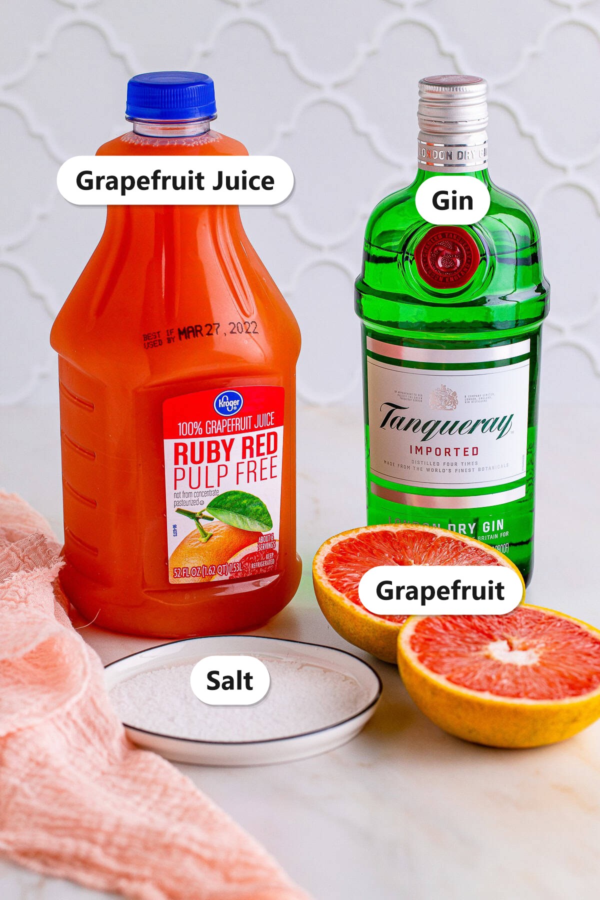 Grapefruit juice, gin, kosher salt, and fresh grapefruit ingredients for a salty dog cocktail.