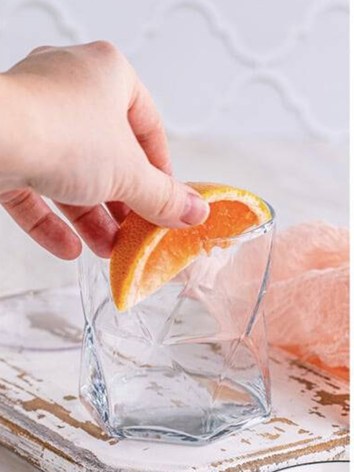 Running a fresh grapefruit wedge around the rim of a cocktail glass.