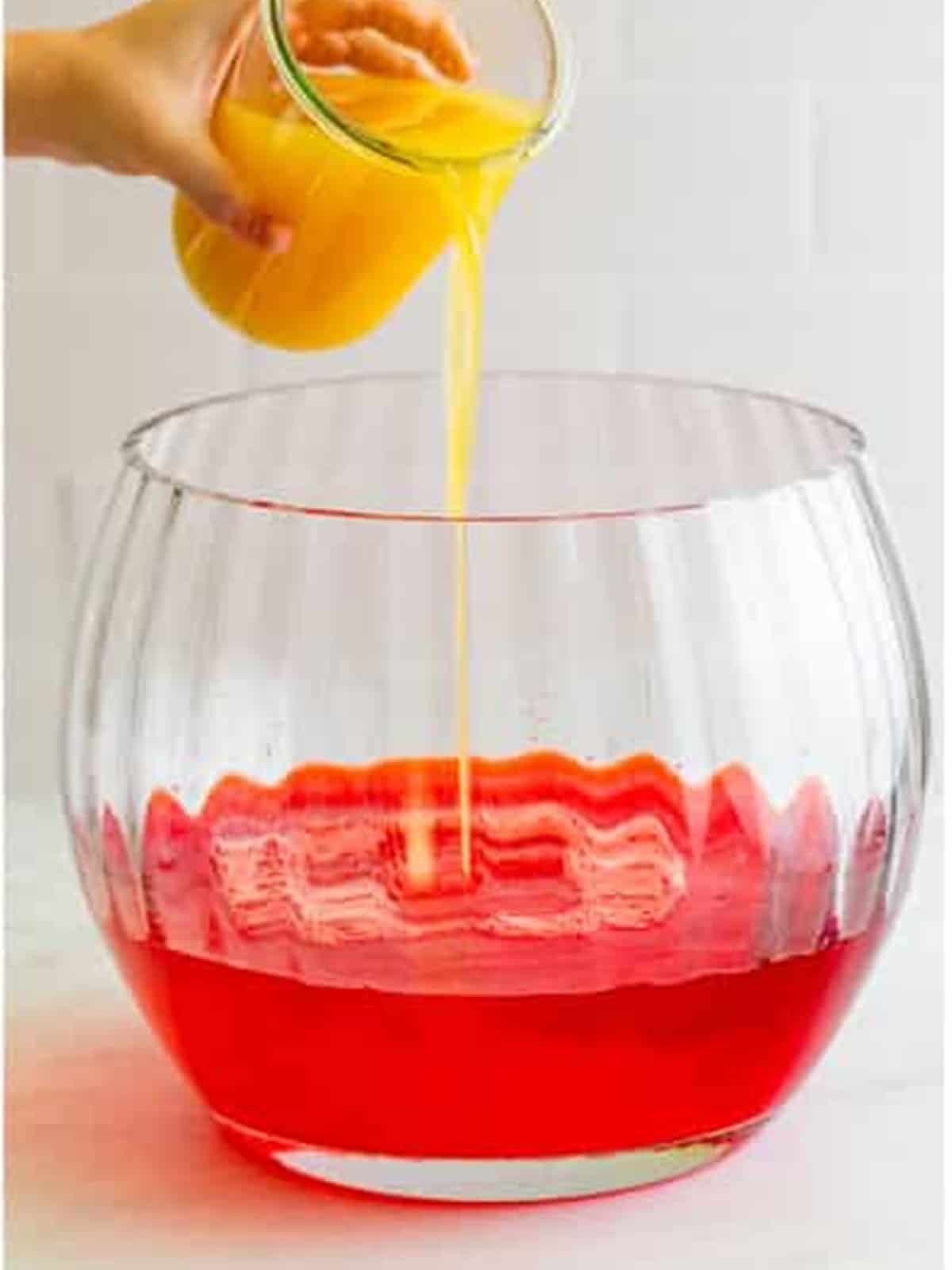 Pineapple juice poured into the punch bowl for Sherbet Punch.