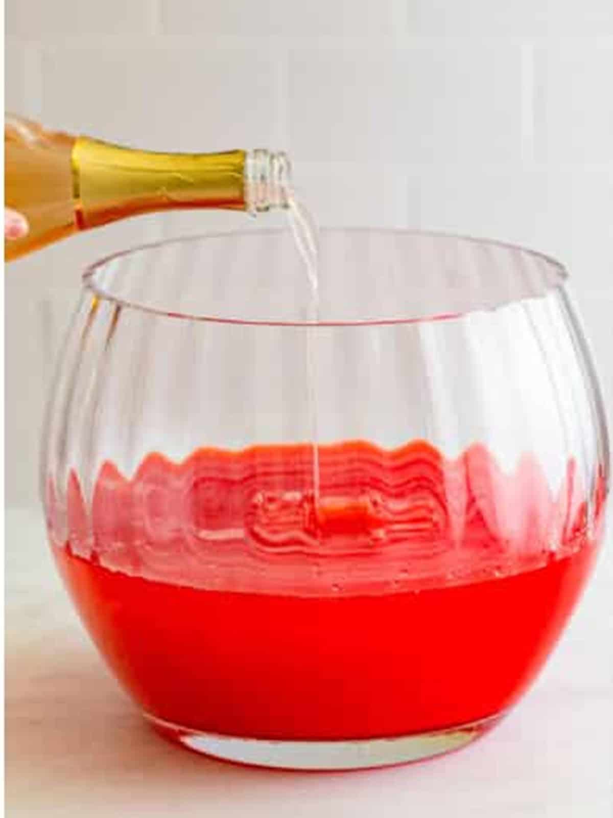 Rose prosecco poured into the Sherbet Punch base in the punch bowl.