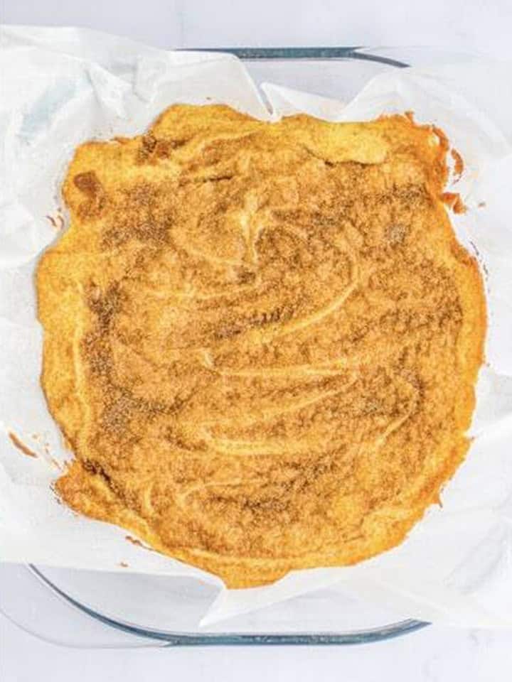 Baked snickerdoodle blondies with a crackly cinnamon sugar top in the pan.