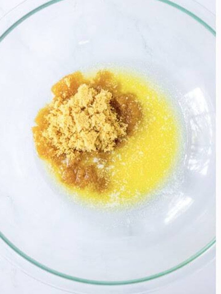 Melted butter and brown sugar combined in a glass mixing bowl.