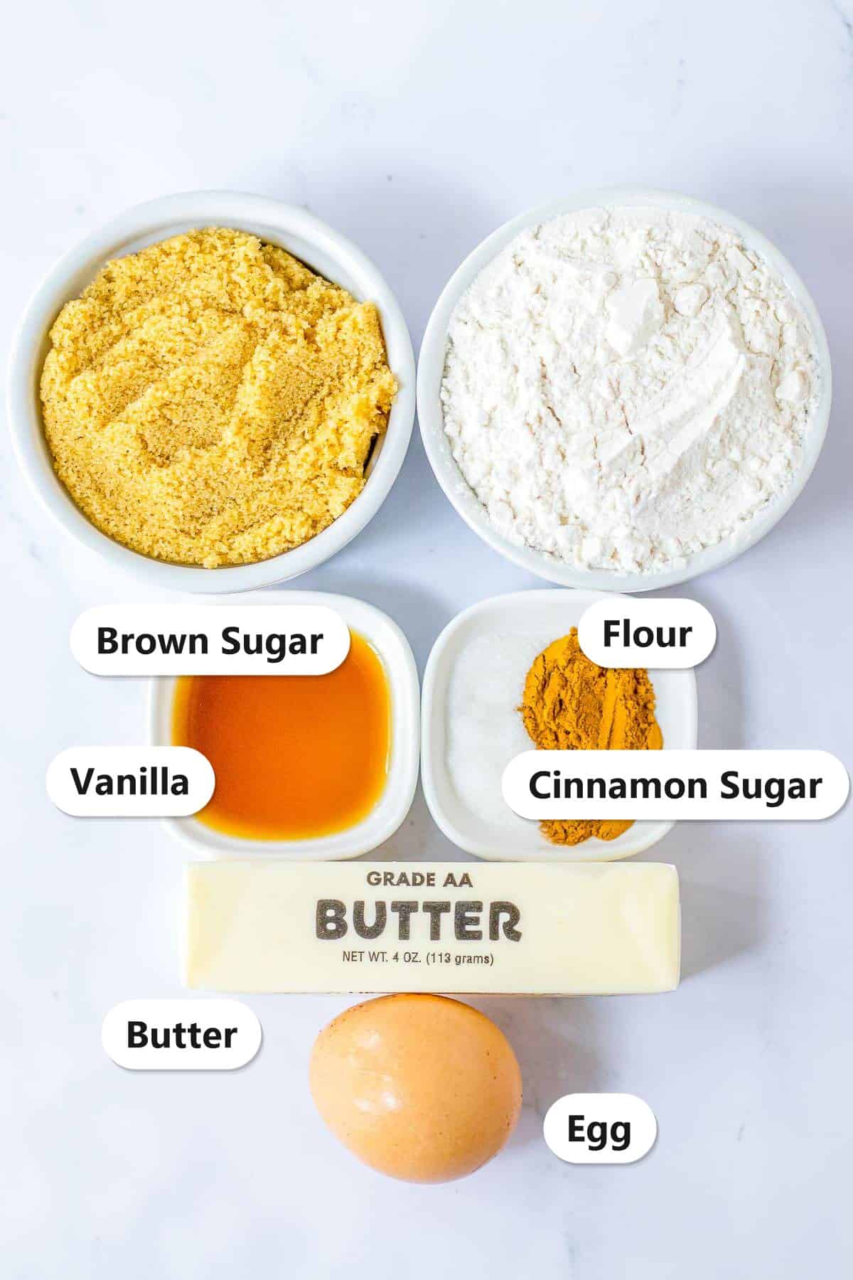 Ingredients to make snickerdoodle blondies: brown sugar, flour, butter, egg, vanilla, and cinnamon sugar.