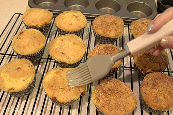 Softened butter brushed onto the tops of baked snickerdoodle cupcakes.