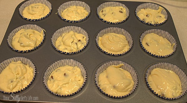 Cupcake liners filled with snickerdoodle cupcakes batter in a muffin tin.