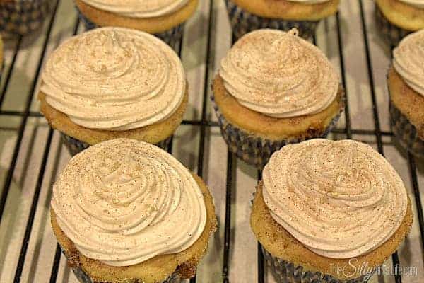 Cinnamon cream cheese frosting swirled onto snickerdoodle cupcakes.