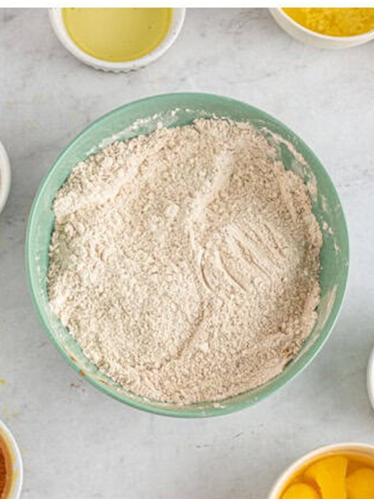 Flour and warm spices whisked together in a bowl for spiced bundt cake.