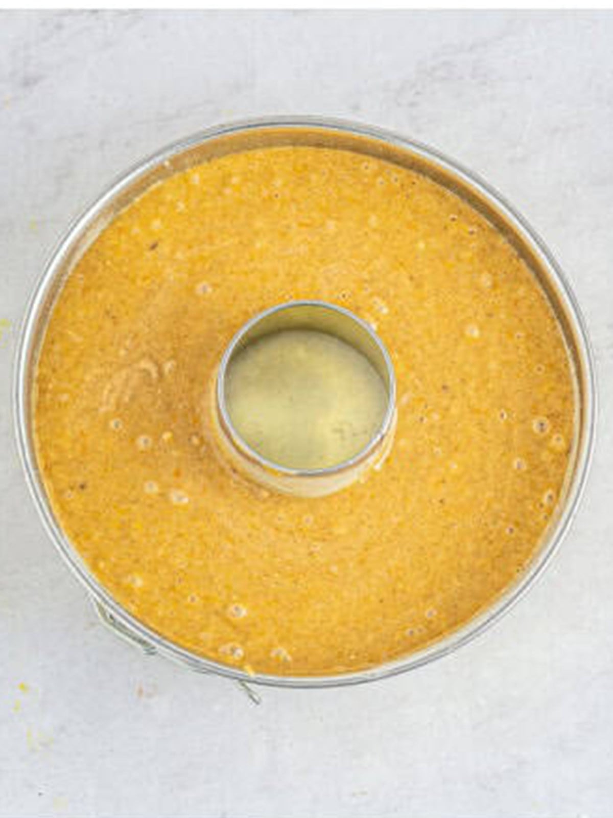 Spiced bundt cake batter poured into a prepared bundt pan before baking.