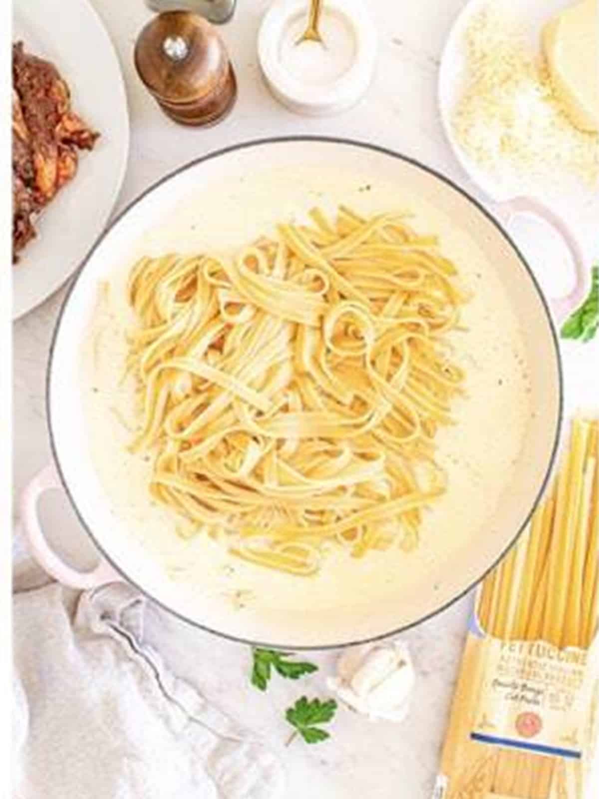Drained fettuccine added to the skillet of alfredo sauce for Steak Alfredo.