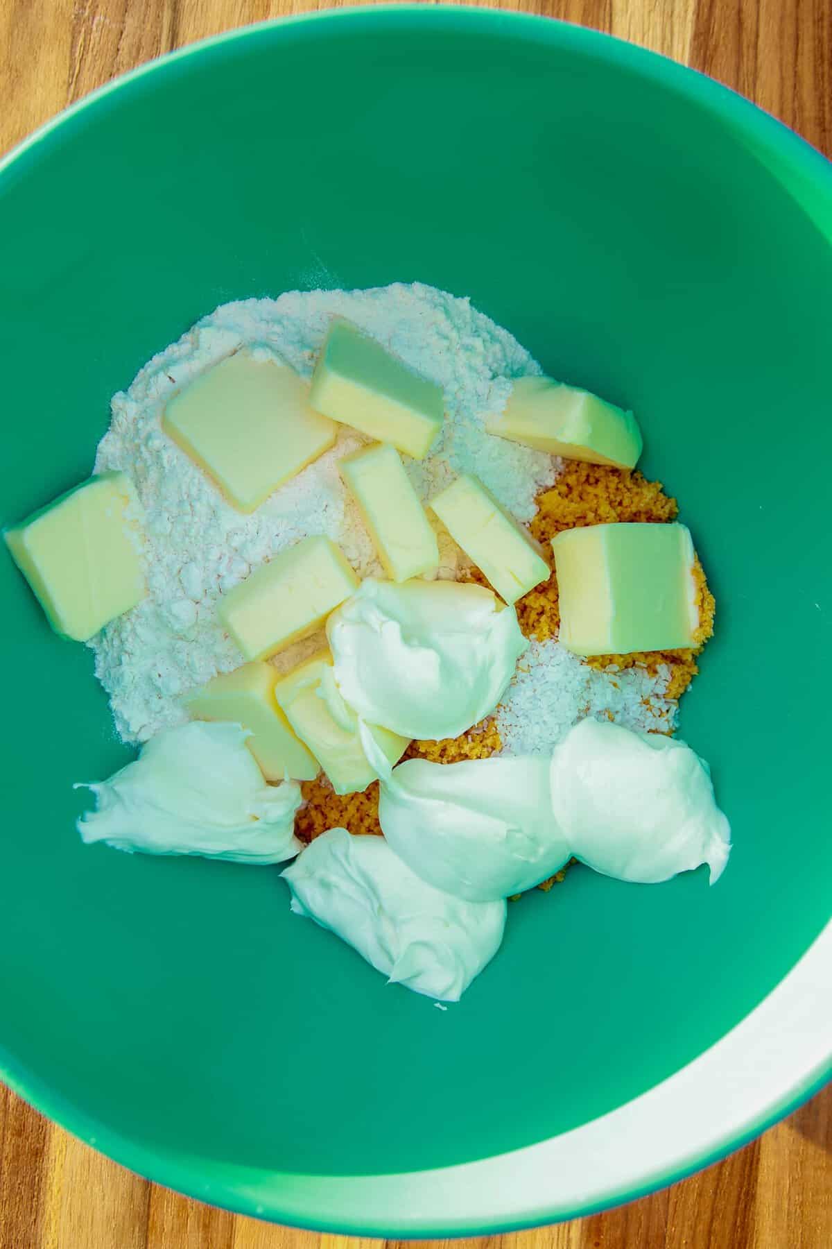 Flour, cubed butter, cream cheese, and crushed Chedz Mild in a bowl for the cheesy crust.