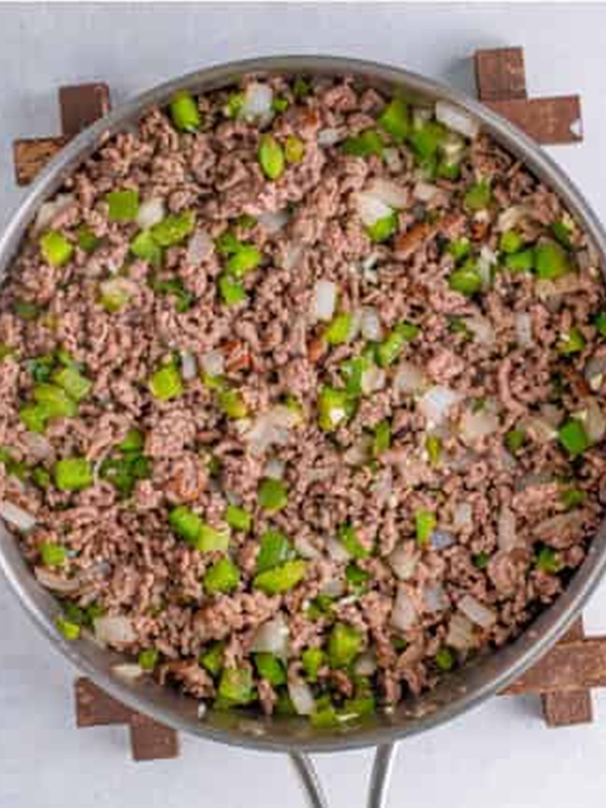 Ground beef browned with diced green pepper and onion in a large skillet