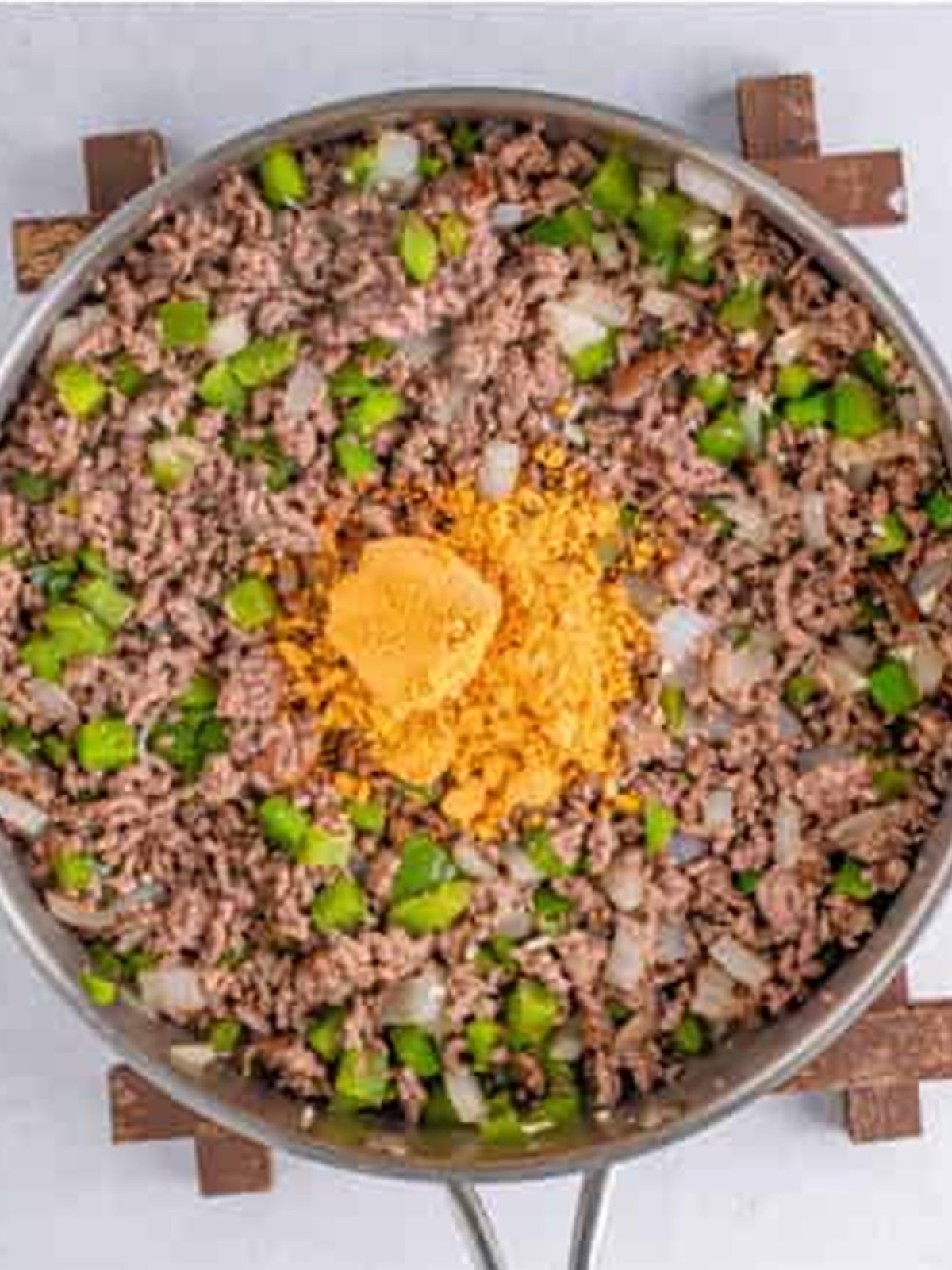 Taco seasoning added to the browned beef and vegetables in the pan