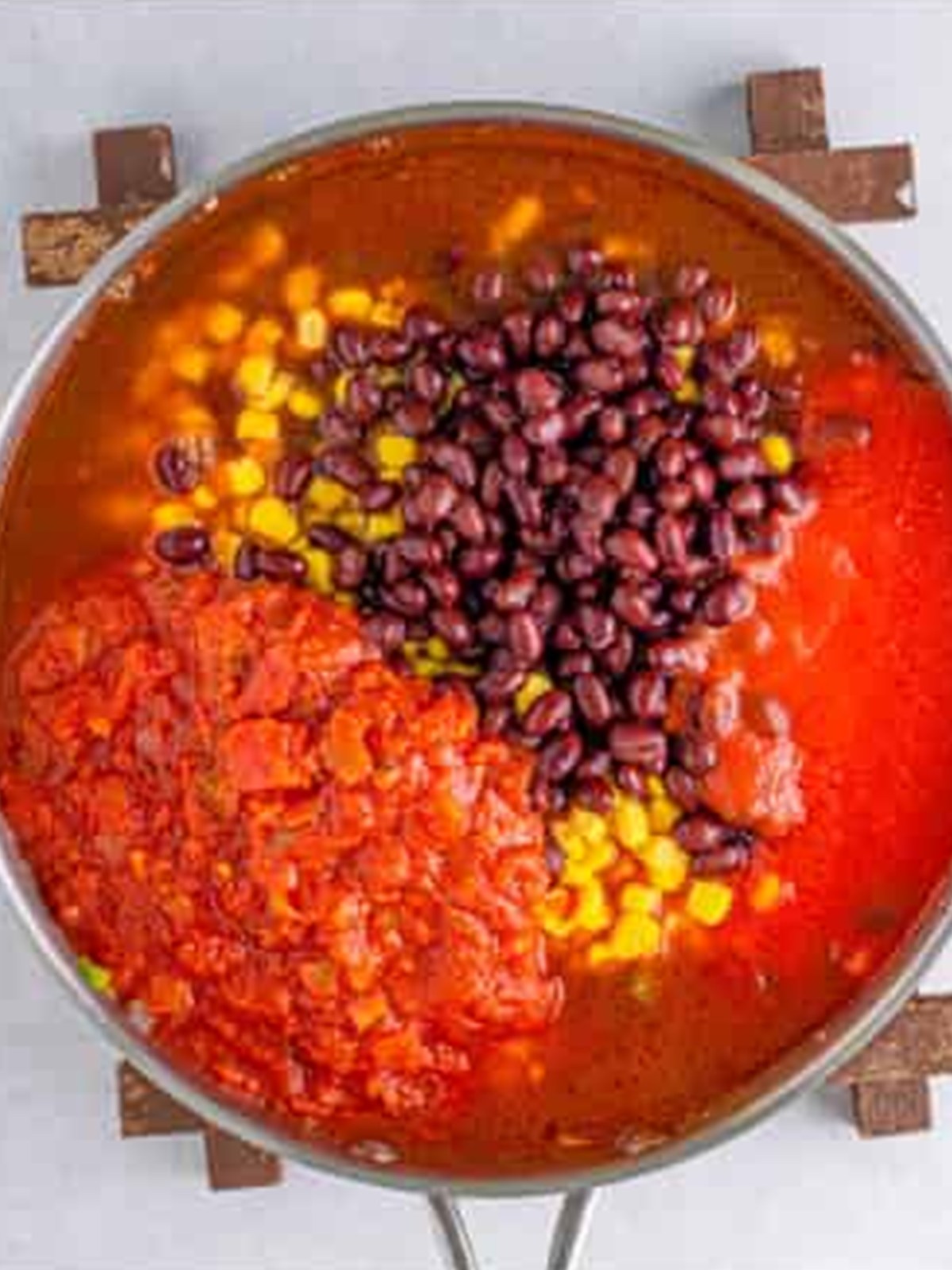 Tomato sauce, salsa, black beans, and corn added to the skillet