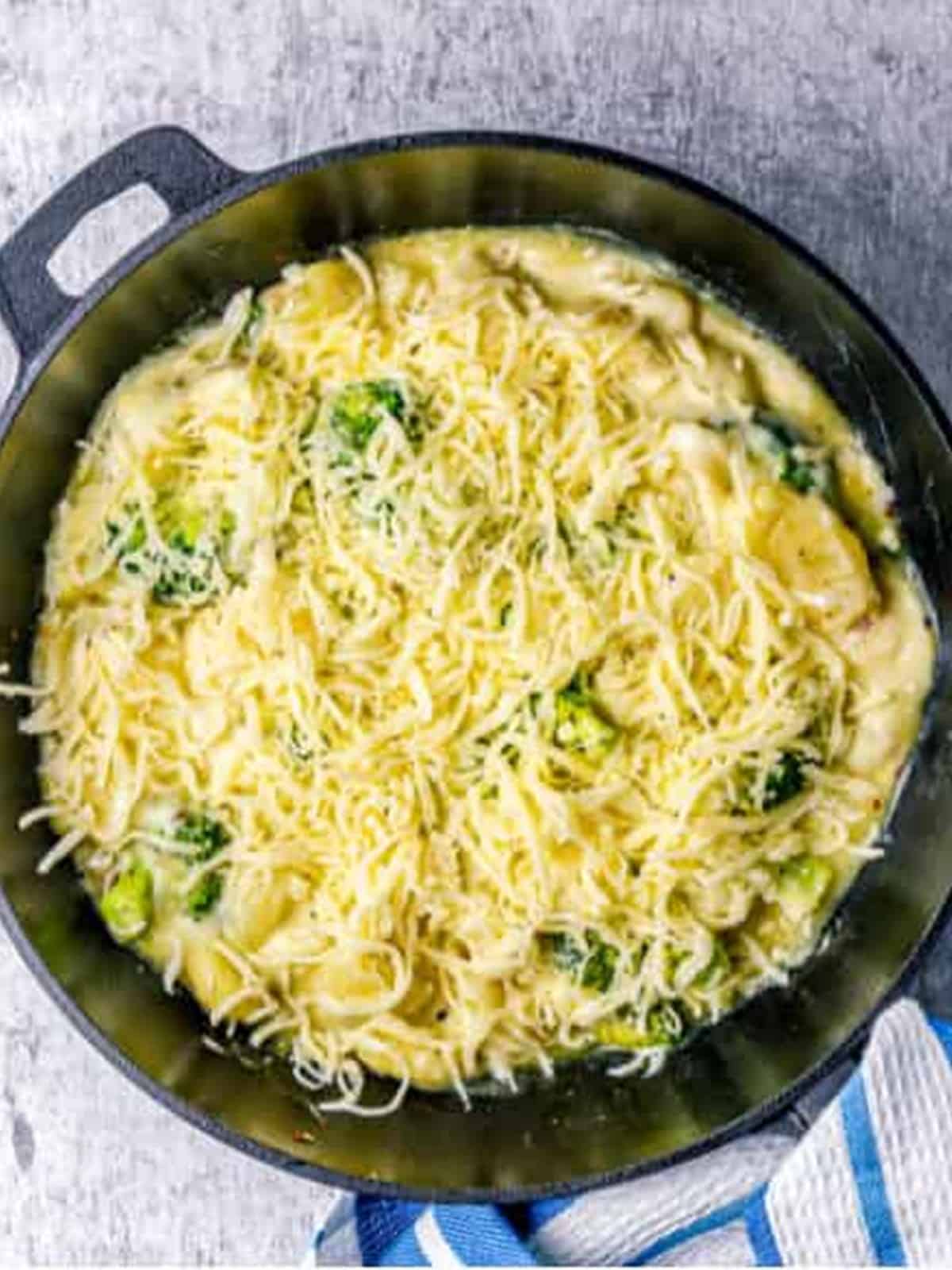 Shredded mozzarella cheese sprinkled over the top of the broccoli gnocchi bake