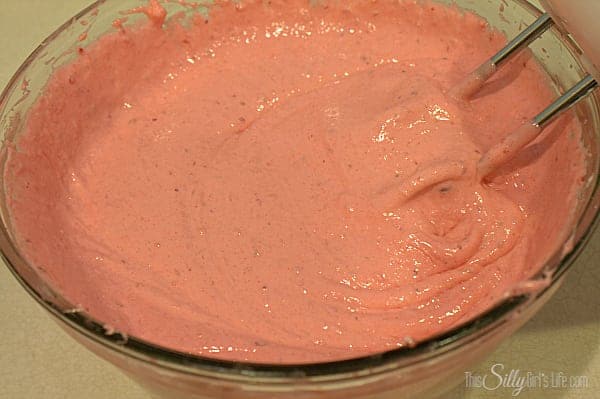 Strawberry donut batter mixed until smooth and bright pink in a glass bowl