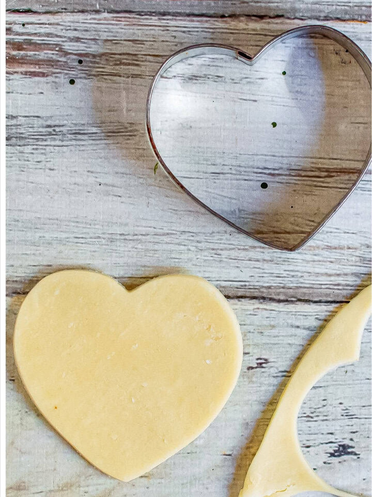 Cutting heart shapes out of rolled pie crust with a heart cookie cutter.