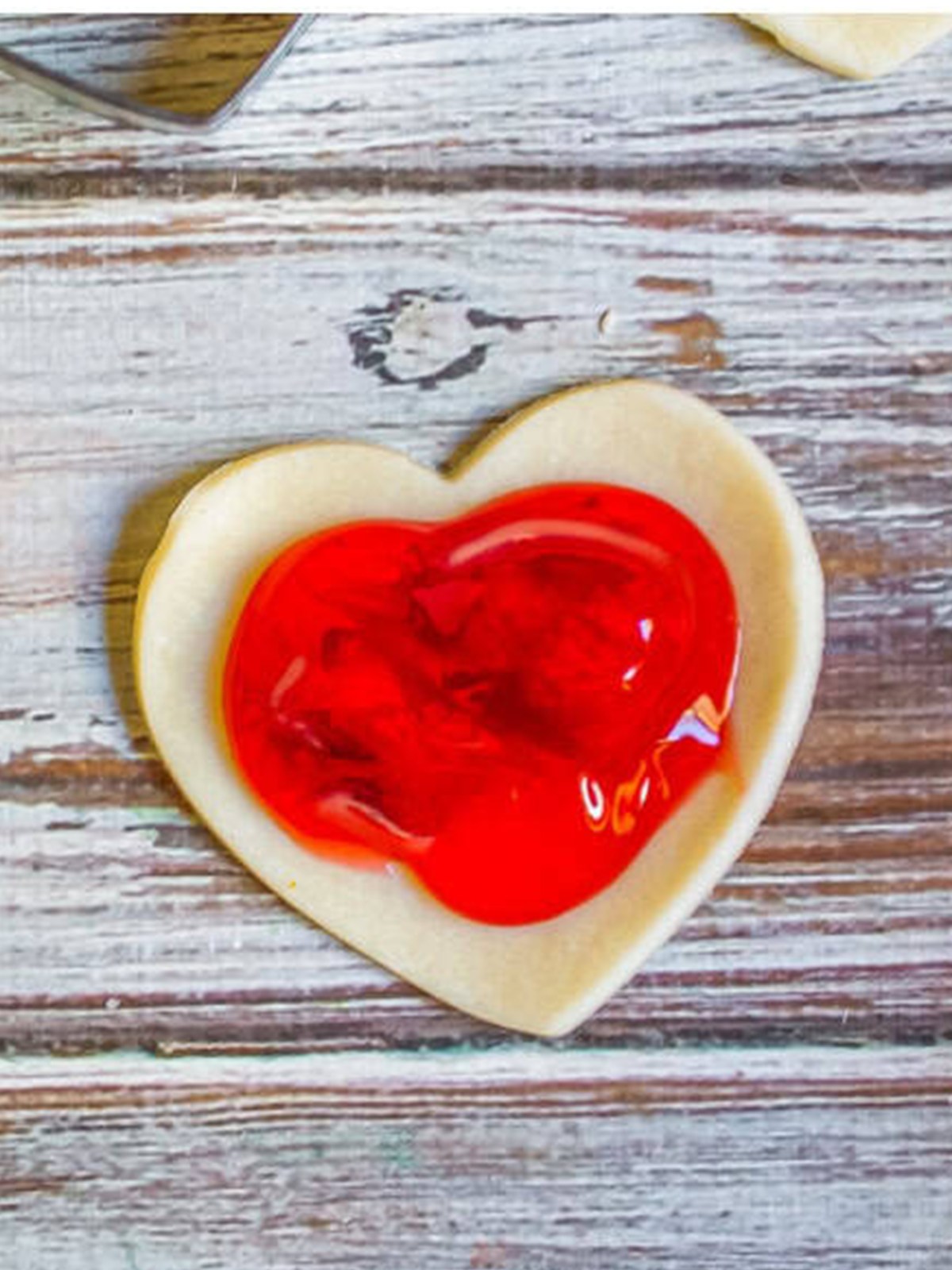 Strawberry pie filling spooned onto the center of a heart shaped crust.