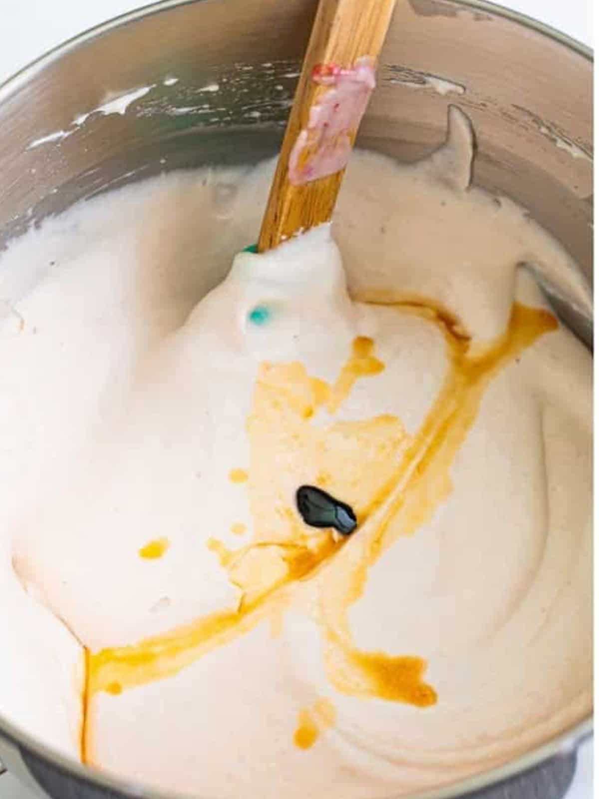 Strawberry mixture streamed into the whipped cream while mixing for no churn Strawberry Ice Cream.