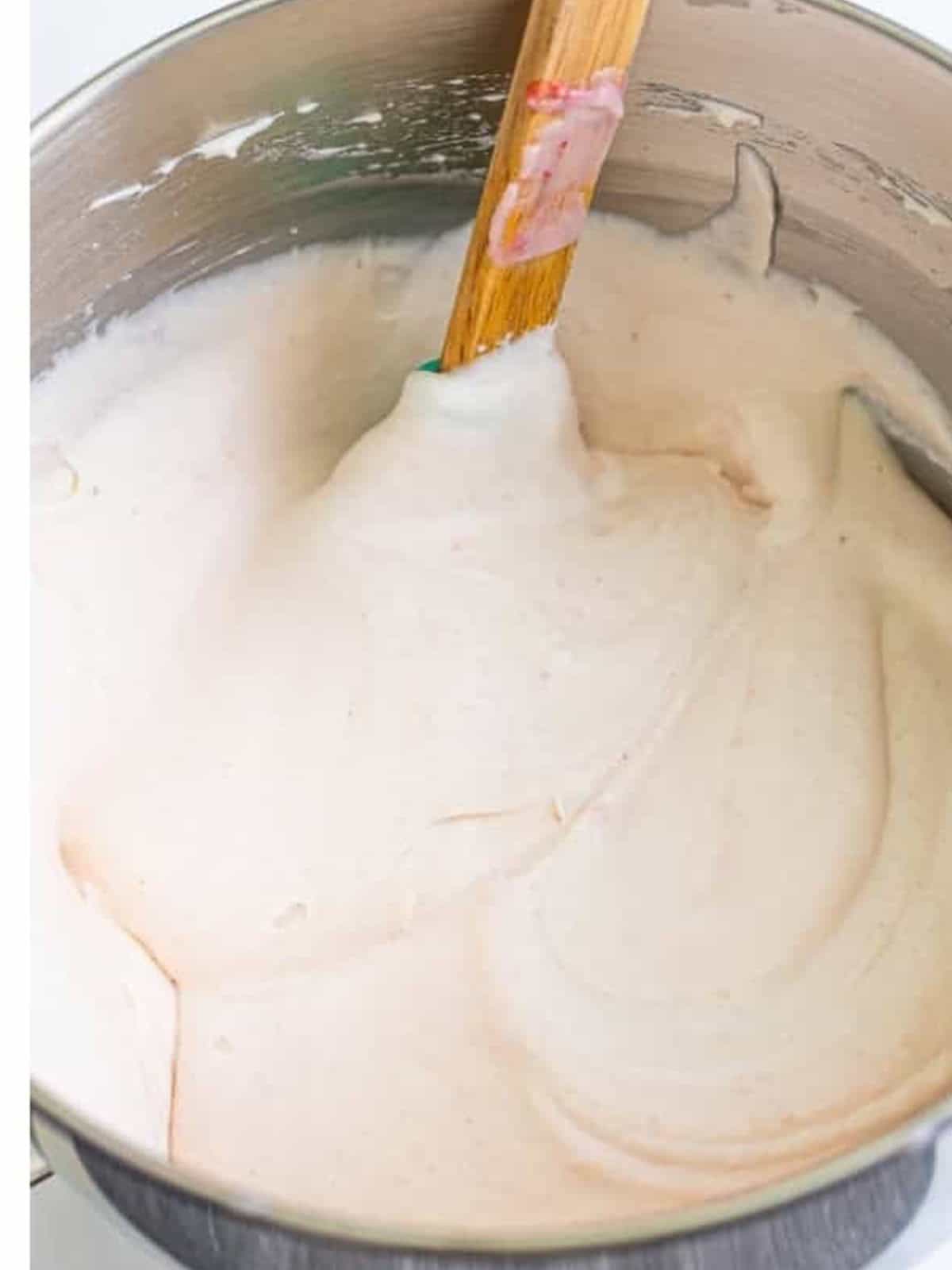 Heavy whipping cream whipped to soft peaks in a large bowl for Strawberry Ice Cream.