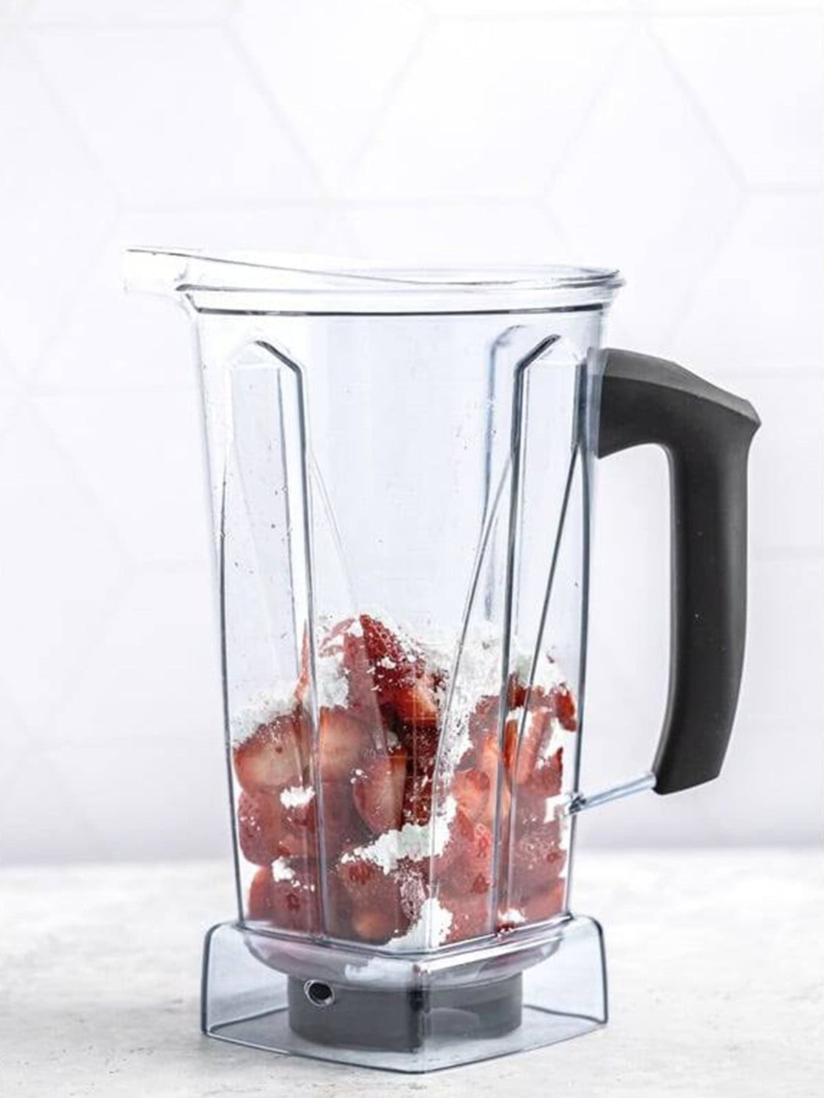 Chopped strawberries, powdered sugar, water, and vanilla in a blender for Strawberry Sauce.