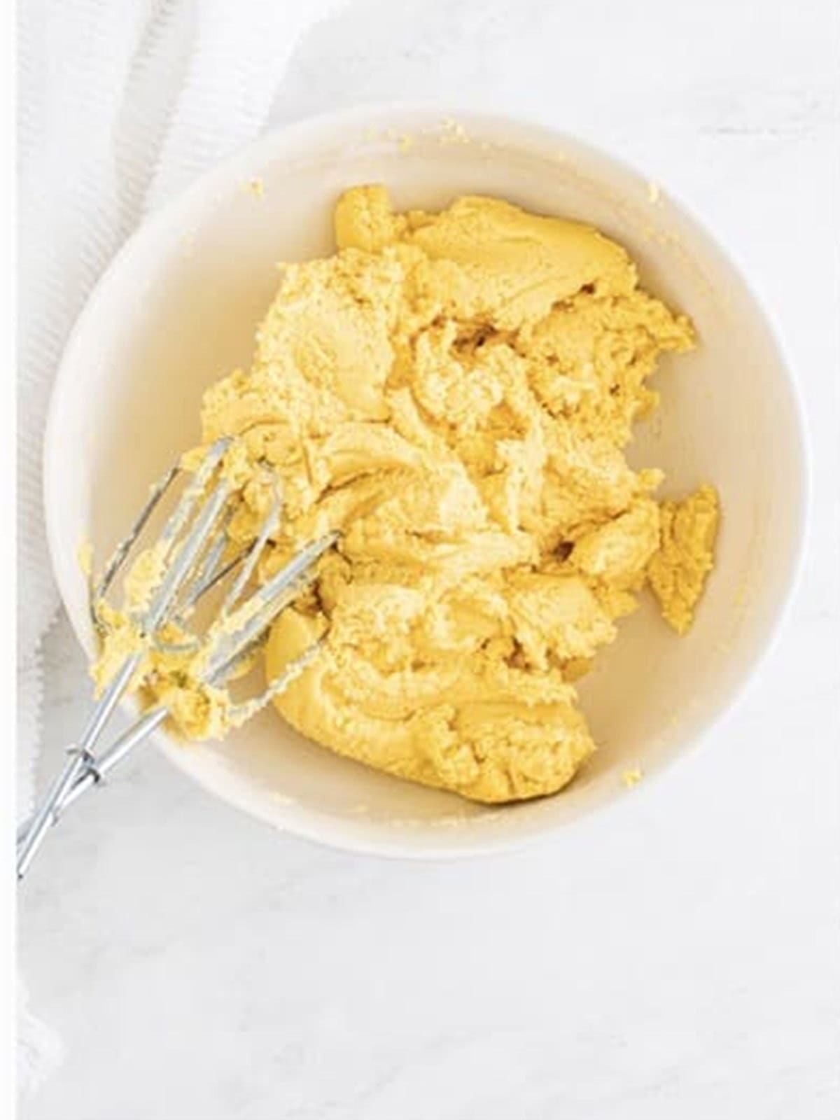 Thick sugar cookie dough mixed in a white bowl.