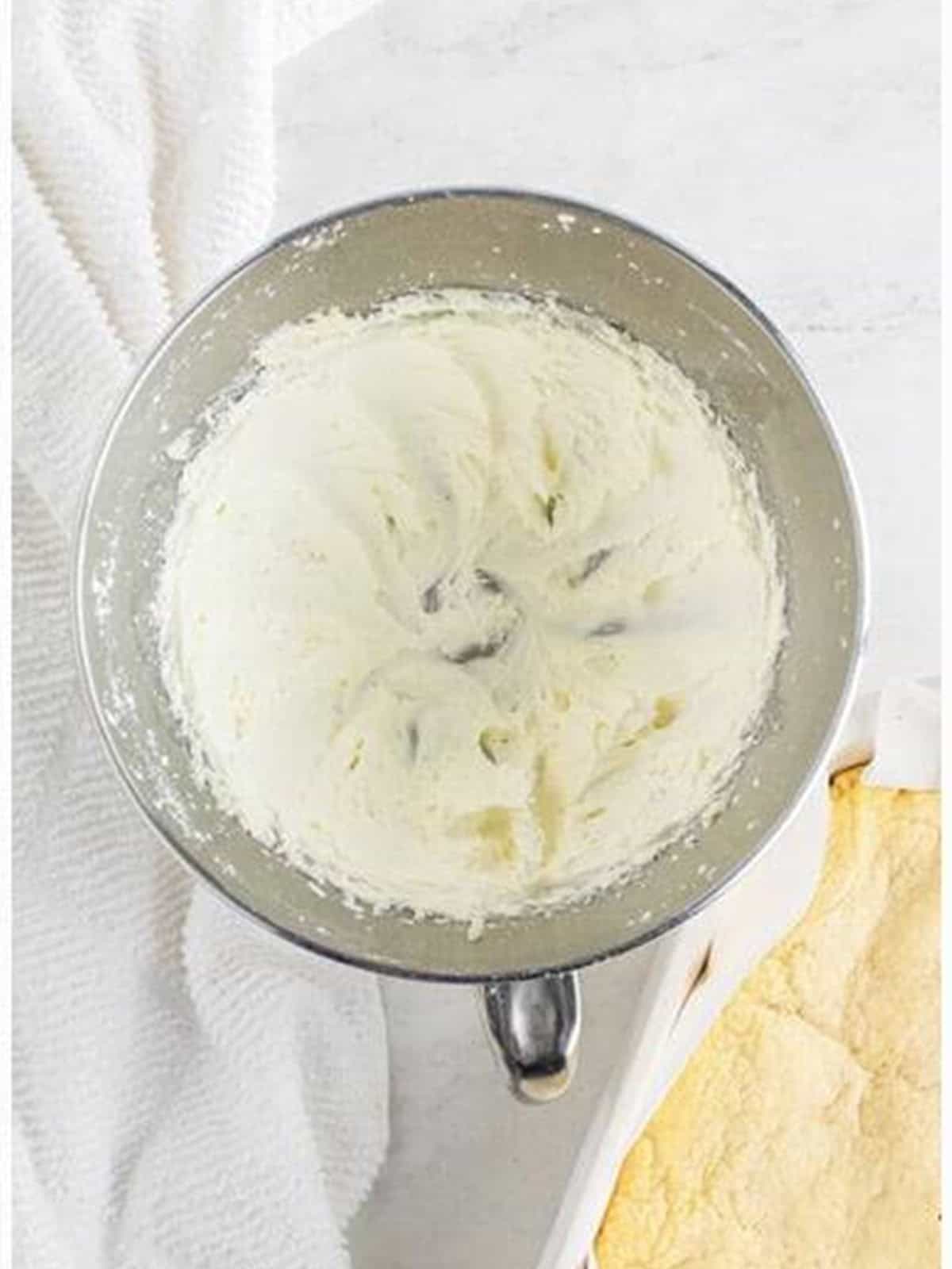 Buttercream frosting whipped fluffy in a mixing bowl.