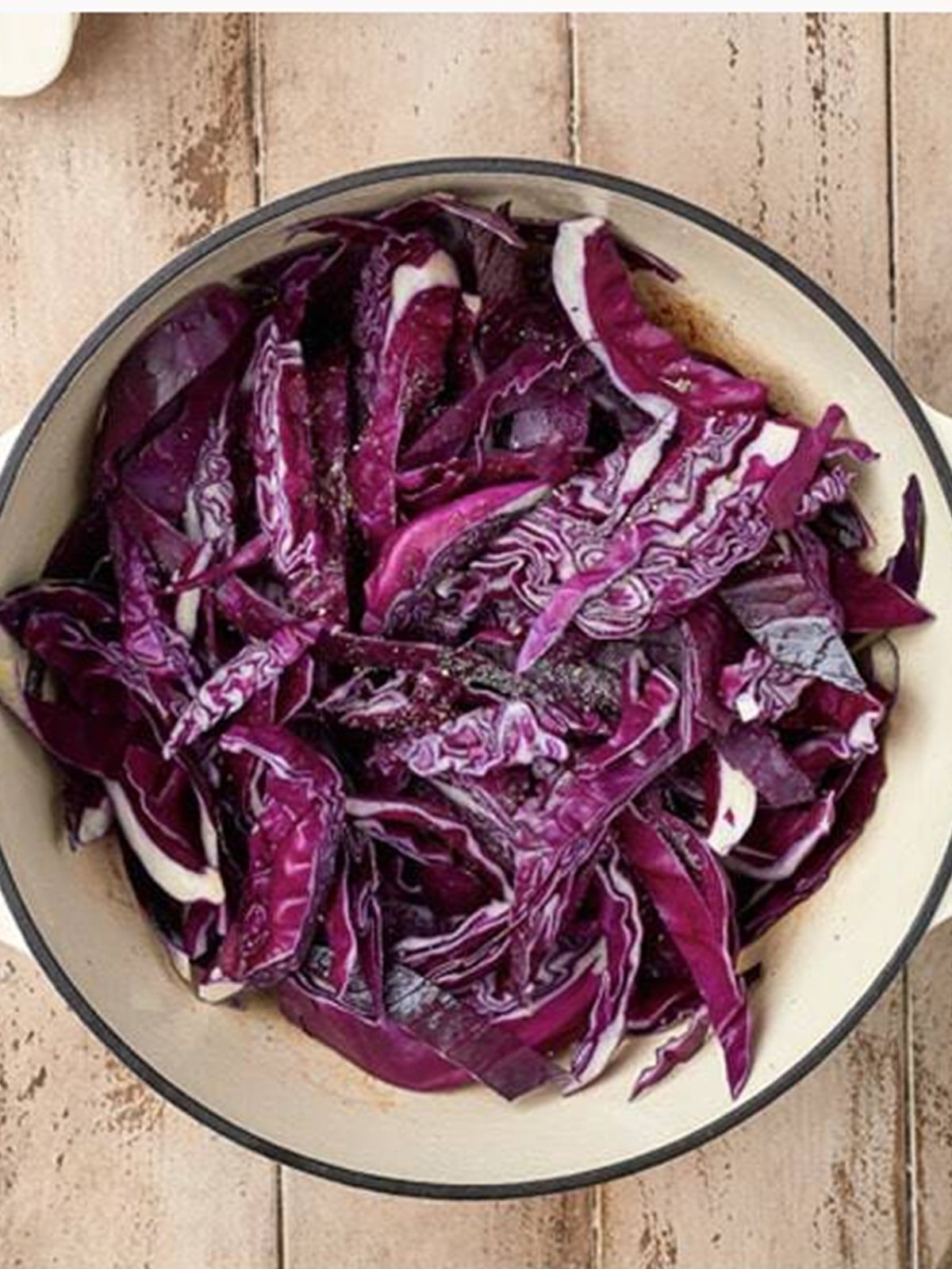 Sliced red cabbage added to the pot and tossed in bacon fat.