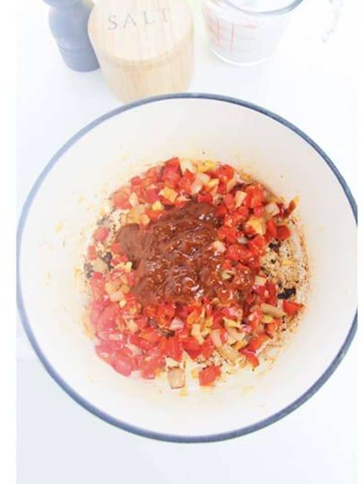 Thai red curry paste added on top of the sauteed aromatics in the pot.