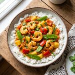 A bowl of Thai Shrimp Curry with shrimp and vegetables over rice.
