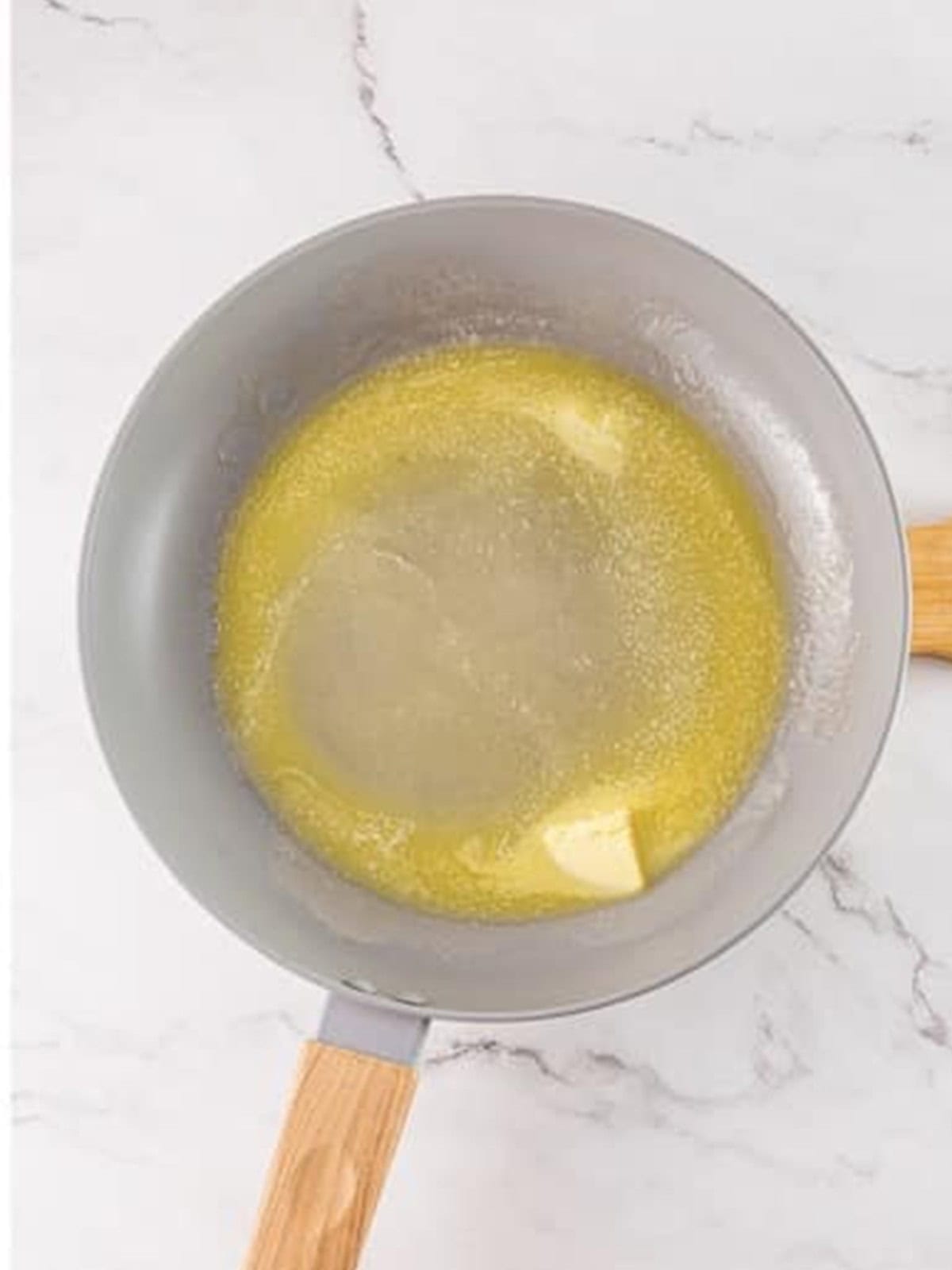 Melting butter in a pan over low heat for Tiramisu French Toast.